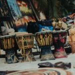 Vibrant traditional drums and crafts at an outdoor market in Abuja, Nigeria.