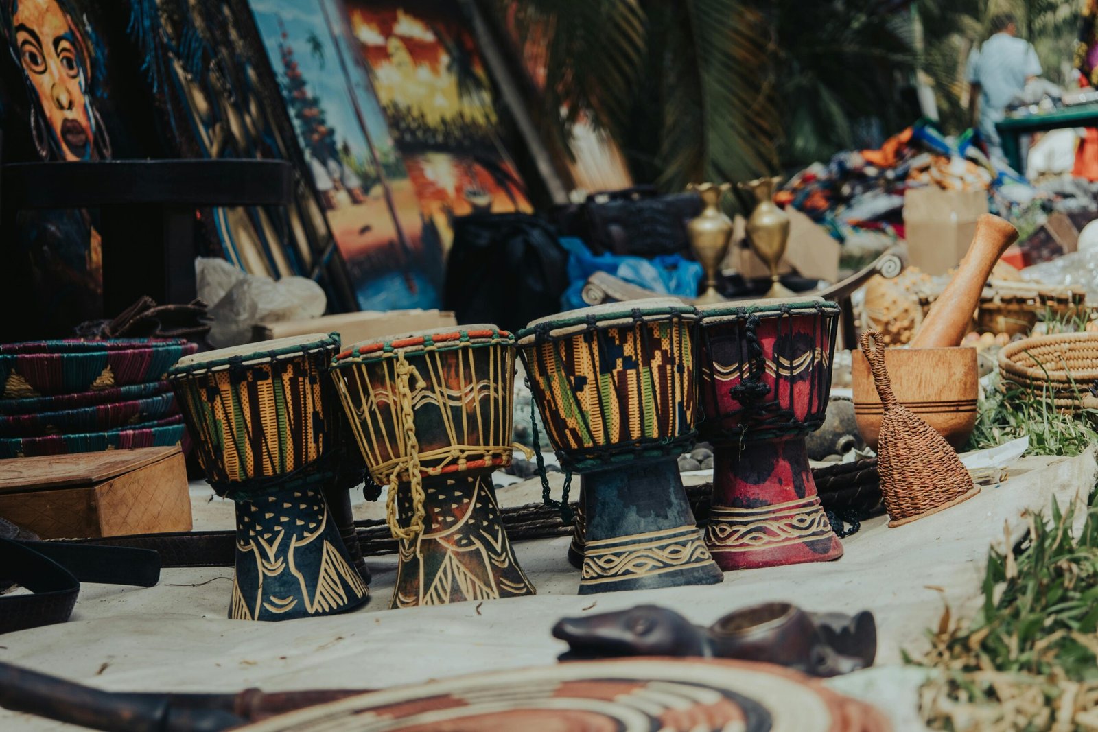 Vibrant traditional drums and crafts at an outdoor market in Abuja, Nigeria.