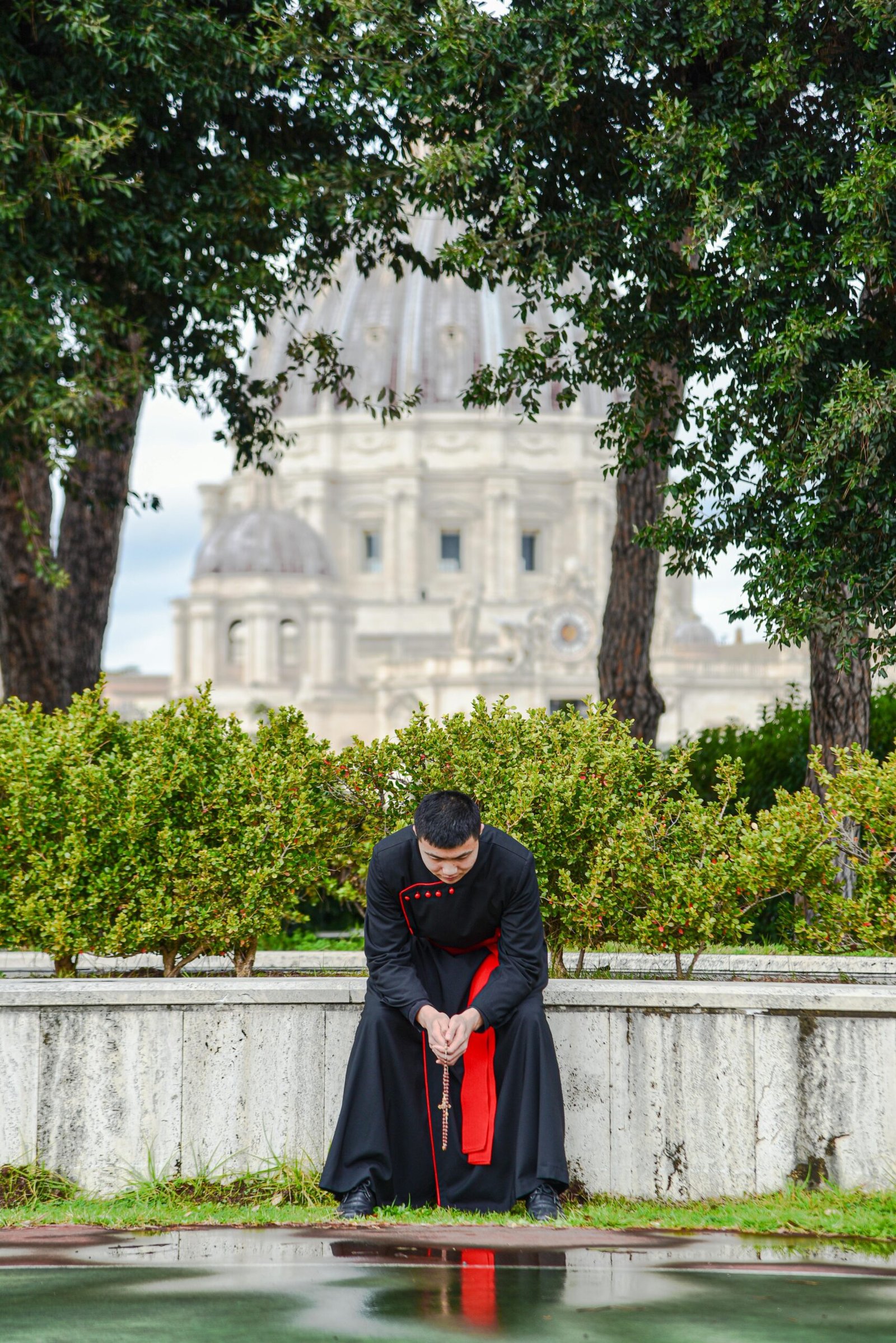 A Catholic priest in prayer near St. Peter's Basilica in Vatican City, Rome, Italy.