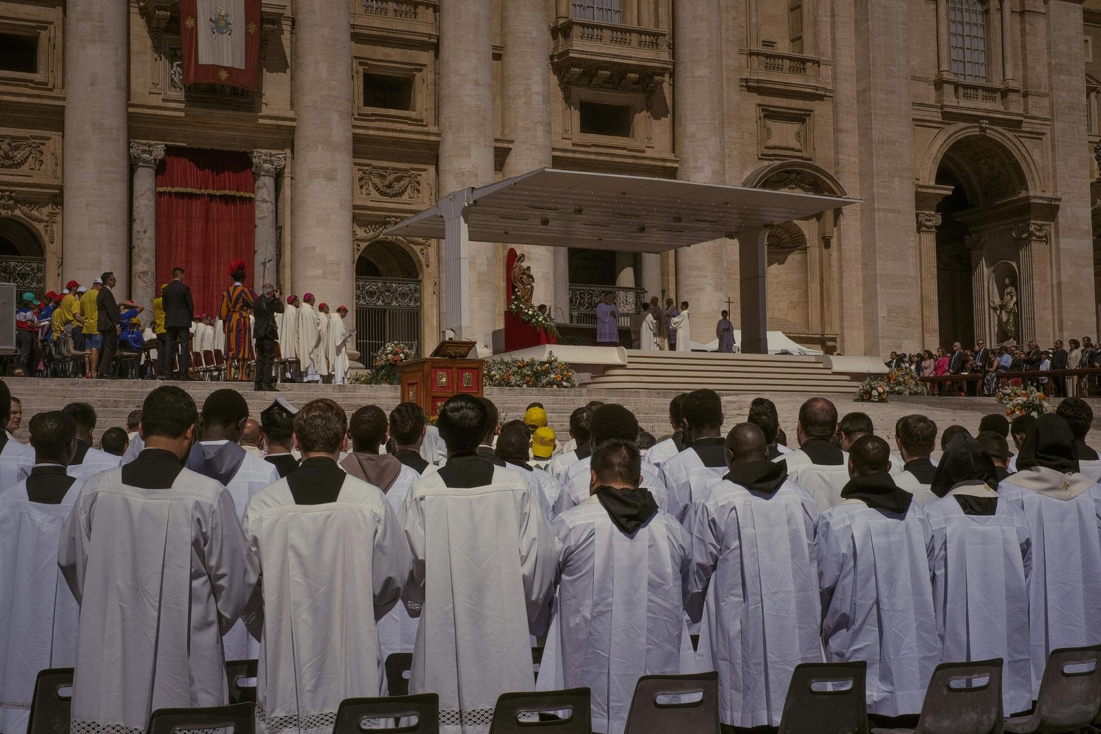 A large gathering of priests at a religious ceremony outside St. Peter's Basilica in Vatican City.